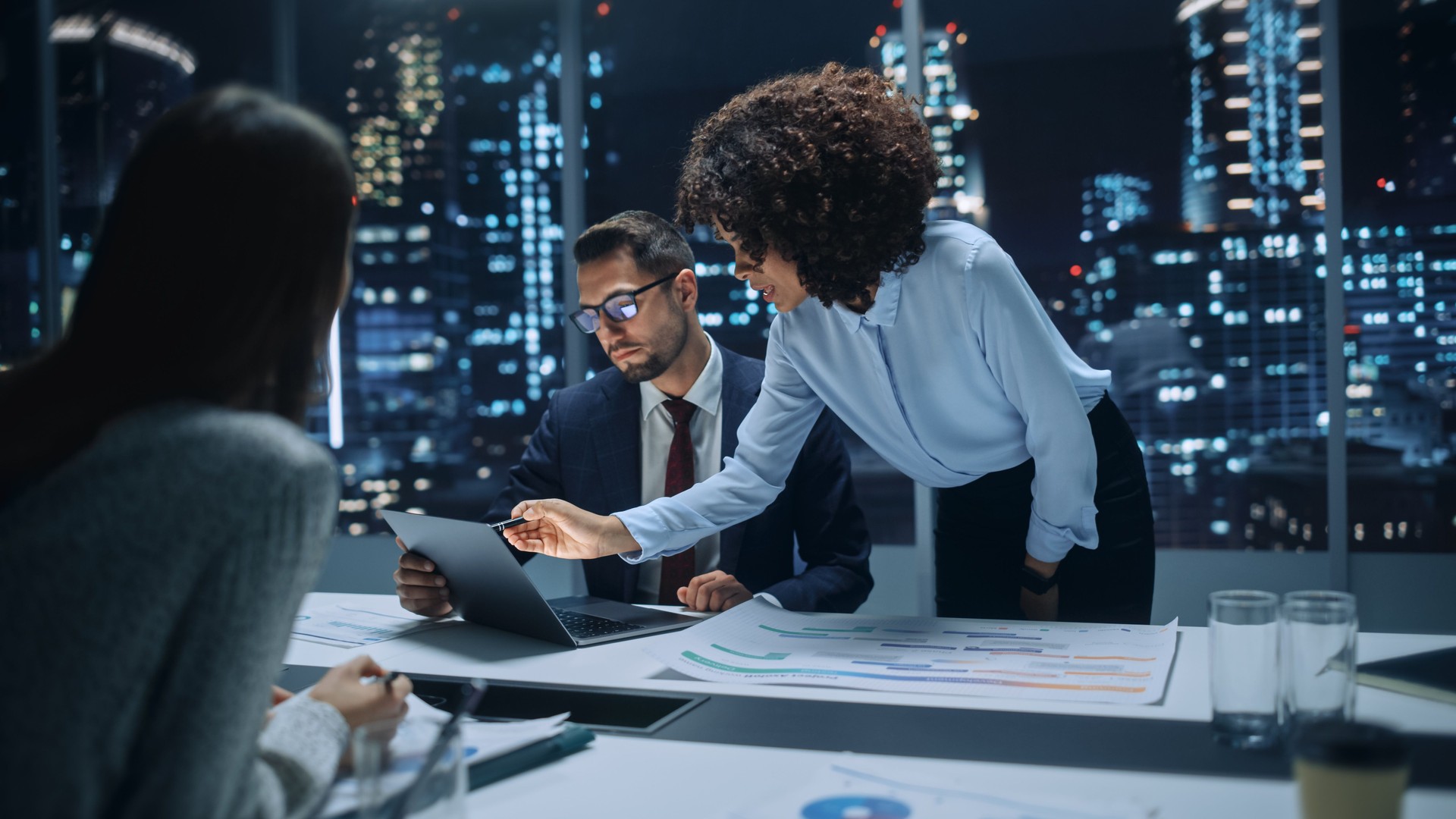 Office Conference Room Meeting: Diverse Team of Top Managers Talk, Brainstorm, Use Laptop Computer. Business Partners Discuss Financial Reports, Plan Operations Based on Line and Pie Graph Reports.