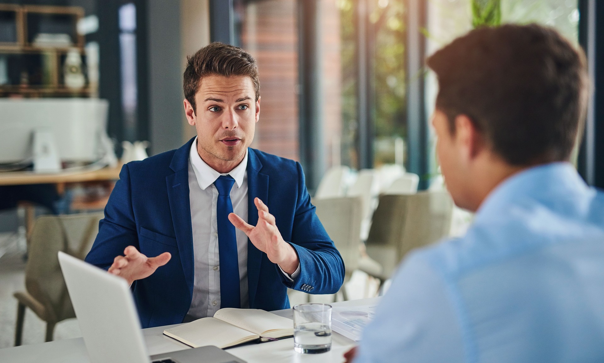 Brainstorming, business people and men in meeting, laptop or conversation with financial advisor, advice for investment or savings. Consultant, cafe or employees with computer, discussion or planning